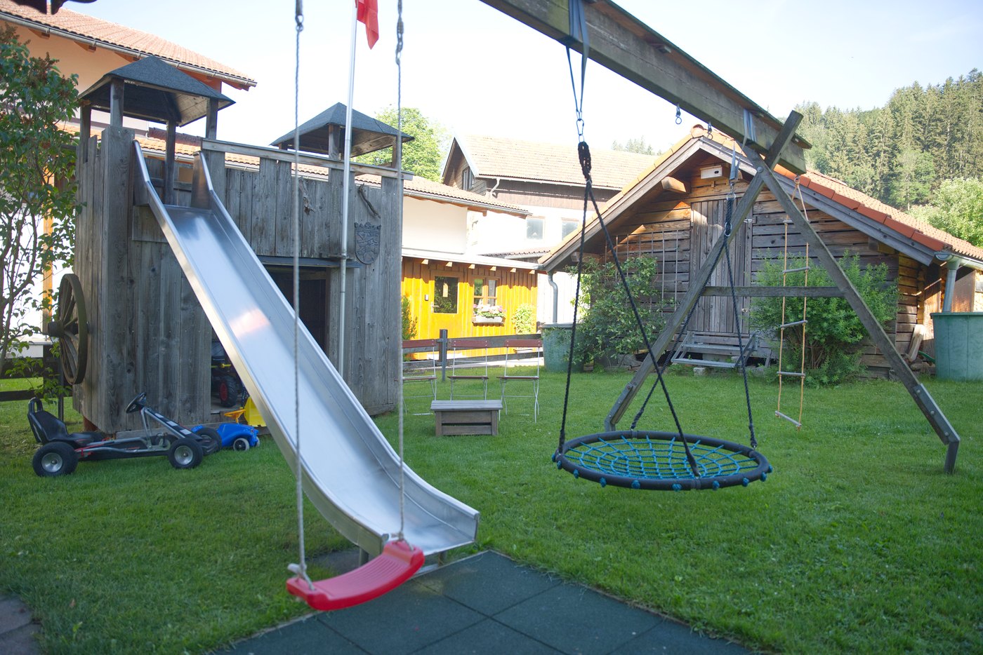 Spielplatz im Garten mit Rutsche, Nestschaukel und Ritterburg