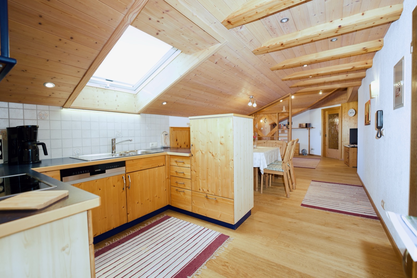 Große Wohnküche mit Holzdecke und Blick zum Essplatz